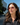 Woman wearing rose-tinted migraine glasses outdoors in bright light