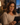 Woman wearing amber sleep support glasses while using a tablet in the evening